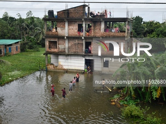 Flood-affected people take shelter in an under-construction building in Feni, Chittagong, Bangladesh, on August 23, 2024. (