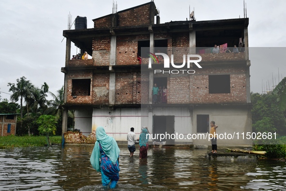 Flood-affected people take shelter in an under-construction building in Feni, Chittagong, Bangladesh, on August 23, 2024. 