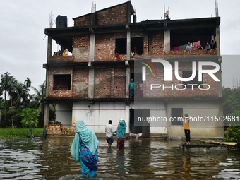 Flood-affected people take shelter in an under-construction building in Feni, Chittagong, Bangladesh, on August 23, 2024. (