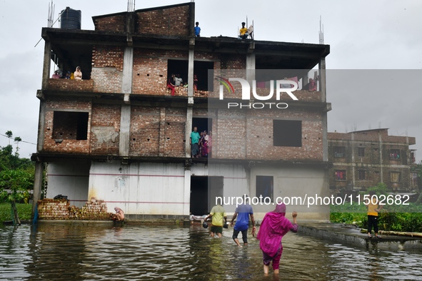 Flood-affected people take shelter in an under-construction building in Feni, Chittagong, Bangladesh, on August 23, 2024. 