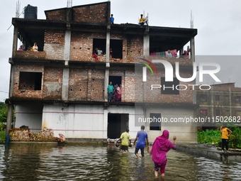 Flood-affected people take shelter in an under-construction building in Feni, Chittagong, Bangladesh, on August 23, 2024. (