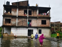 Flood-affected people take shelter in an under-construction building in Feni, Chittagong, Bangladesh, on August 23, 2024. (