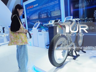 Visitors view a ''spokeless hydrogen bicycle'' at the HICOOL 2024 Global Entrepreneurs Summit in Beijing, China, on August 23, 2024. (