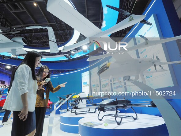 Visitors visit the ''hanging Compound Wing unmanned transport aircraft'' at the HICOOL 2024 Global Entrepreneurs Summit in Beijing, China, o...