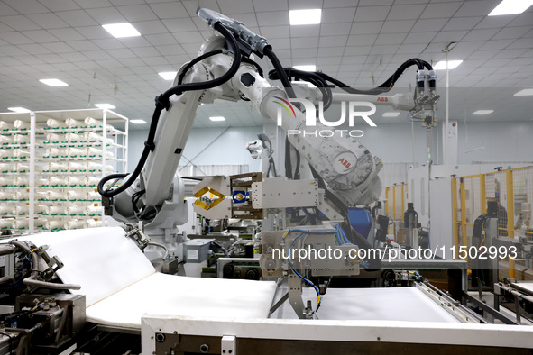 A robot produces a reverse osmosis membrane on a production line at the digital intelligent production workshop of Fujian Huameo Environment...