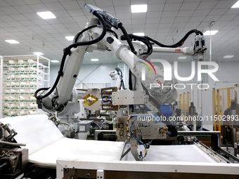 A robot produces a reverse osmosis membrane on a production line at the digital intelligent production workshop of Fujian Huameo Environment...