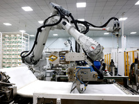 A robot produces a reverse osmosis membrane on a production line at the digital intelligent production workshop of Fujian Huameo Environment...