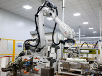 A robot produces a reverse osmosis membrane on a production line at the digital intelligent production workshop of Fujian Huameo Environment...