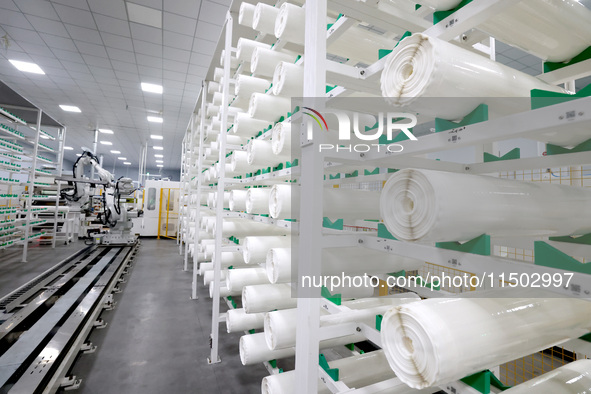 A robot produces a reverse osmosis membrane on a production line at the digital intelligent production workshop of Fujian Huameo Environment...