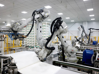 A robot produces a reverse osmosis membrane on a production line at the digital intelligent production workshop of Fujian Huameo Environment...