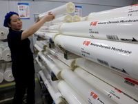 A worker produces reverse osmosis membranes on a production line at the digital intelligent production workshop of Fujian Huameo Environment...