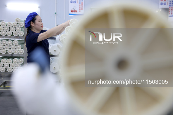 A worker produces reverse osmosis membranes on a production line at the digital intelligent production workshop of Fujian Huameo Environment...