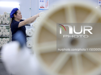 A worker produces reverse osmosis membranes on a production line at the digital intelligent production workshop of Fujian Huameo Environment...