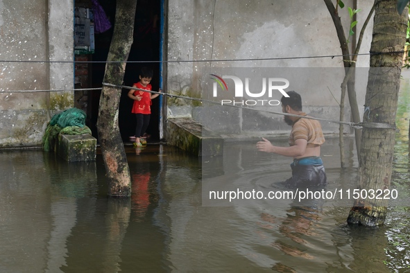 Local residents shift to temporary shelter homes as floodwater rises in their homes in Feni, Chittagong, Bangladesh, on August 23, 2024. 