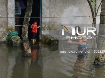 Local residents shift to temporary shelter homes as floodwater rises in their homes in Feni, Chittagong, Bangladesh, on August 23, 2024. (