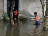 Local residents shift to temporary shelter homes as floodwater rises in their homes in Feni, Chittagong, Bangladesh, on August 23, 2024. (