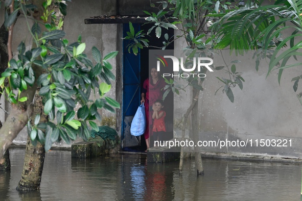 Local residents shift to temporary shelter homes as floodwater rises in their homes in Feni, Chittagong, Bangladesh, on August 23, 2024. 