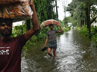 Volunteers carry relief supplies while wading through floodwater in Feni, Chittagong, Bangladesh, on August 23, 2024. (