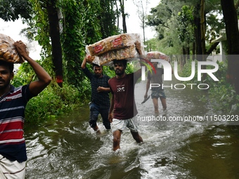 Volunteers carry relief supplies while wading through floodwater in Feni, Chittagong, Bangladesh, on August 23, 2024. (