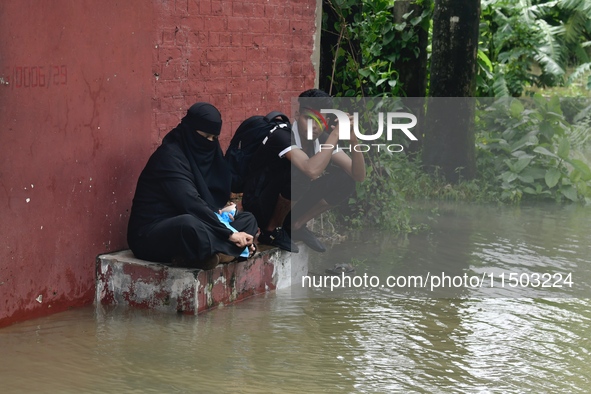 People are stuck due to floodwater in the rail track area in Feni, Chittagong, Bangladesh, on August 23, 2024. 