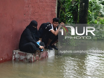 People are stuck due to floodwater in the rail track area in Feni, Chittagong, Bangladesh, on August 23, 2024. (