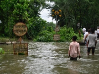 People wade through a submerged rail track due to floodwater in Feni, Chittagong, Bangladesh, on August 23, 2024. (