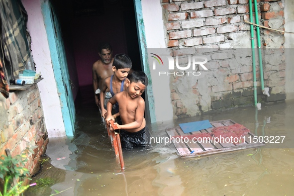 Local residents shift to temporary shelter homes as floodwater rises in their homes in Feni, Chittagong, Bangladesh, on August 23, 2024. 