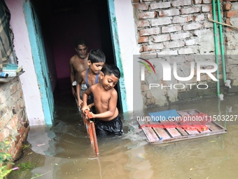 Local residents shift to temporary shelter homes as floodwater rises in their homes in Feni, Chittagong, Bangladesh, on August 23, 2024. (