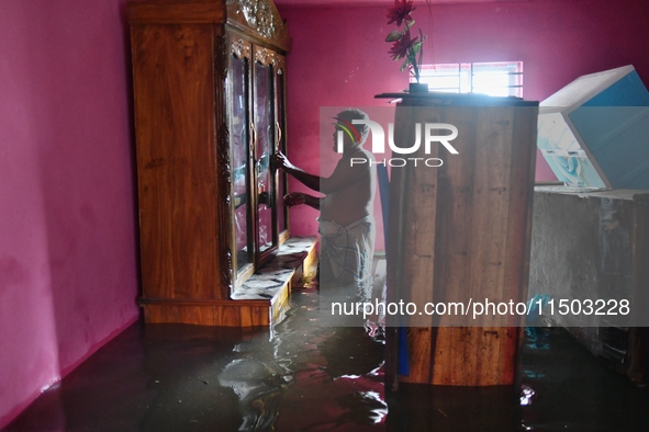 Local residents shift to temporary shelter homes as floodwater rises in their homes in Feni, Chittagong, Bangladesh, on August 23, 2024. 