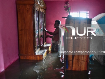 Local residents shift to temporary shelter homes as floodwater rises in their homes in Feni, Chittagong, Bangladesh, on August 23, 2024. (