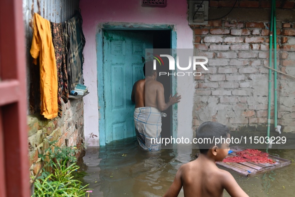 Local residents shift to temporary shelter homes as floodwater rises in their homes in Feni, Chittagong, Bangladesh, on August 23, 2024. 