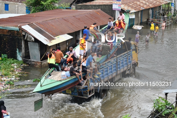 Volunteers carry a boat on a truck to help flood-affected people in Feni, Chittagong, Bangladesh, on August 23, 2024. 