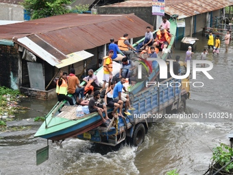 Volunteers carry a boat on a truck to help flood-affected people in Feni, Chittagong, Bangladesh, on August 23, 2024. (