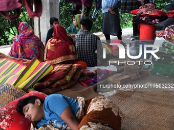 Flood-affected people take shelter in an under-construction building in Feni, Chittagong, Bangladesh, on August 23, 2024. (