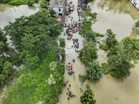 An aerial view shows volunteers rescuing flood-affected residents in the Mohipal area of Feni district in Chittagong division, Bangladesh, o...