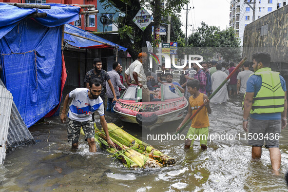 Volunteers use a boat to help rescue people on a flooded street in the Mohipal area of Feni district in Chittagong division, Bangladesh, on...