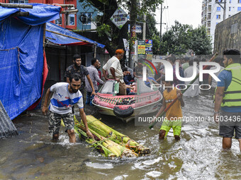 Volunteers use a boat to help rescue people on a flooded street in the Mohipal area of Feni district in Chittagong division, Bangladesh, on...