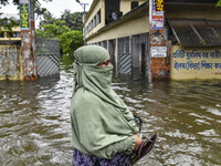 A woman wades through floodwaters in the Mohipal area of Feni district in Chittagong division, Bangladesh, on August 23, 2024. At least 13 p...