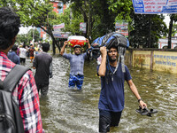 People wade through floodwaters in the Mohipal area of Feni district in Chittagong division, Bangladesh, on August 23, 2024. At least 13 peo...