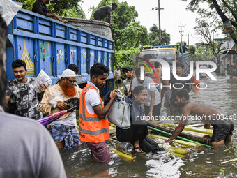 Volunteers rescue a flood-affected woman in the Mohipal area of Feni district in Chittagong division, Bangladesh, on August 23, 2024. At lea...