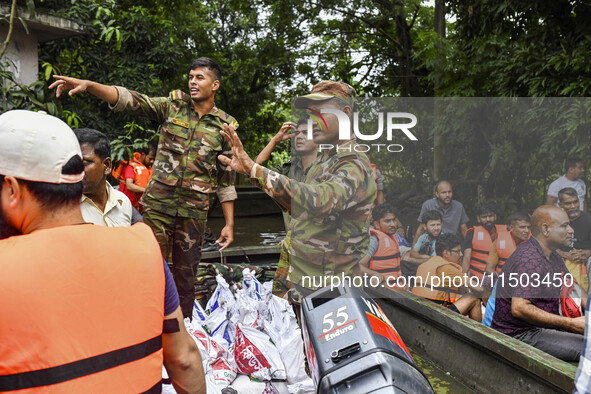 Bangladesh army personnel distribute relief material to the flooded areas in the Mohipal area of Feni district in Chittagong division, Bangl...