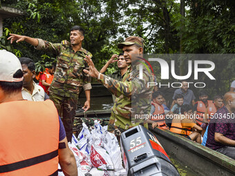 Bangladesh army personnel distribute relief material to the flooded areas in the Mohipal area of Feni district in Chittagong division, Bangl...