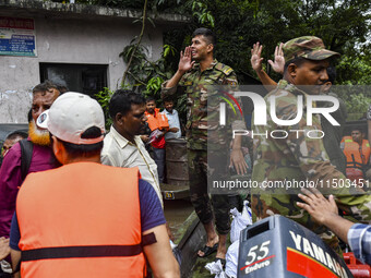 Bangladesh army personnel distribute relief material to the flooded areas in the Mohipal area of Feni district in Chittagong division, Bangl...