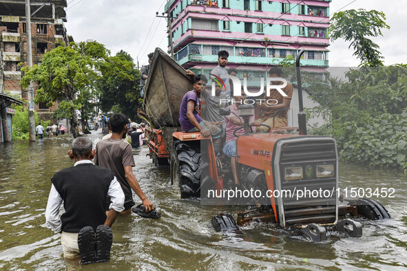 Volunteers carry a boat on a tractor to help flood-affected people in the Mohipal area of Feni district in Chittagong division, Bangladesh,...