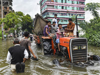 Volunteers carry a boat on a tractor to help flood-affected people in the Mohipal area of Feni district in Chittagong division, Bangladesh,...