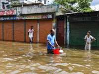 People wade through floodwaters in the Mohipal area of Feni district in Chittagong division, Bangladesh, on August 23, 2024. At least 13 peo...