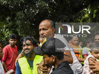 Volunteers rescue flood-affected residents in the Mohipal area of Feni district in Chittagong division, Bangladesh, on August 23, 2024. At l...