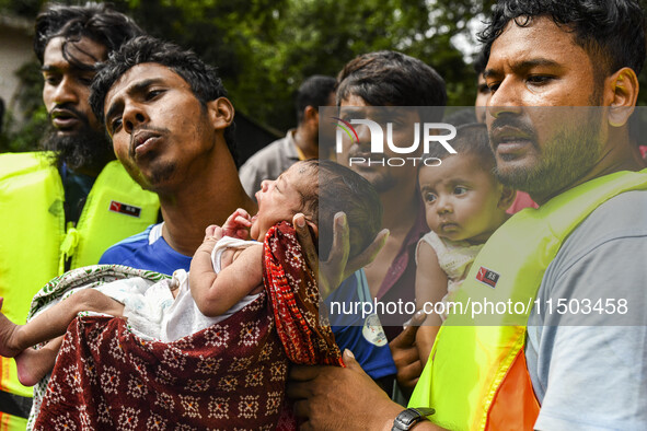 Volunteers rescue a flood-affected 10-day-old child in the Mohipal area of Feni district in Chittagong division, Bangladesh, on August 23, 2...