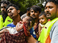 Volunteers rescue a flood-affected 10-day-old child in the Mohipal area of Feni district in Chittagong division, Bangladesh, on August 23, 2...