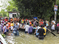 People wade through floodwaters in the Mohipal area of Feni district in Chittagong division, Bangladesh, on August 23, 2024. At least 13 peo...